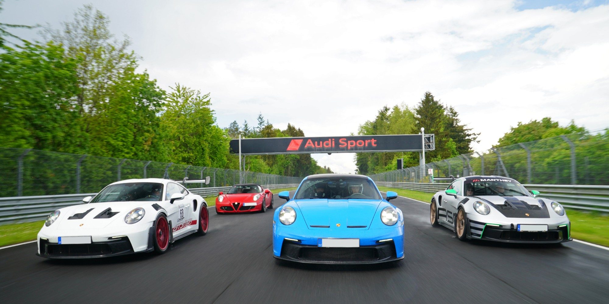 Porsche 911 GT3 RS, GT3 und Alfa Romeo 4C unter der Audi-Sport-Brücke am Nürburgring